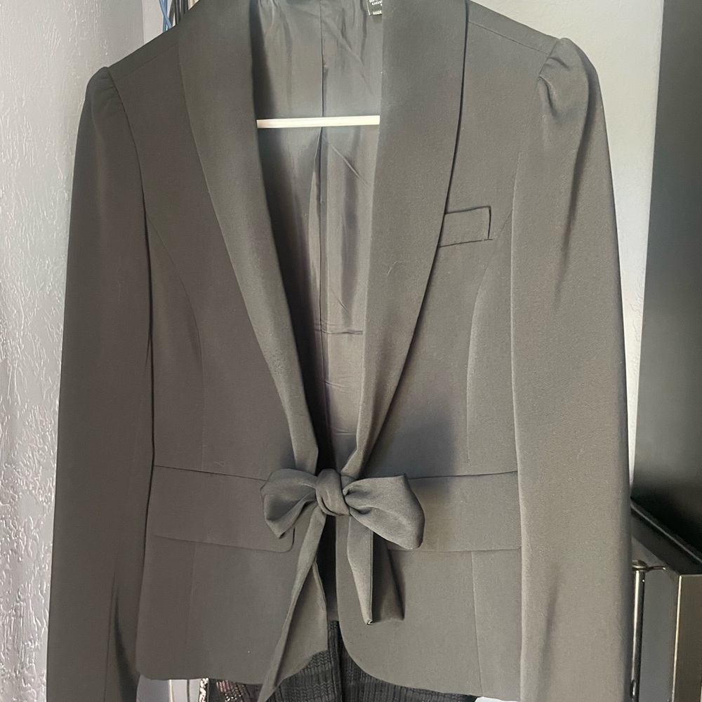 VS suit jacket in black.  Ties with bow. Very chic with clean lines.